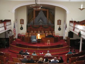 The audience starts to arrive. A view from our balcony of the front of the sanctuary transformed into Scrooge's living room.